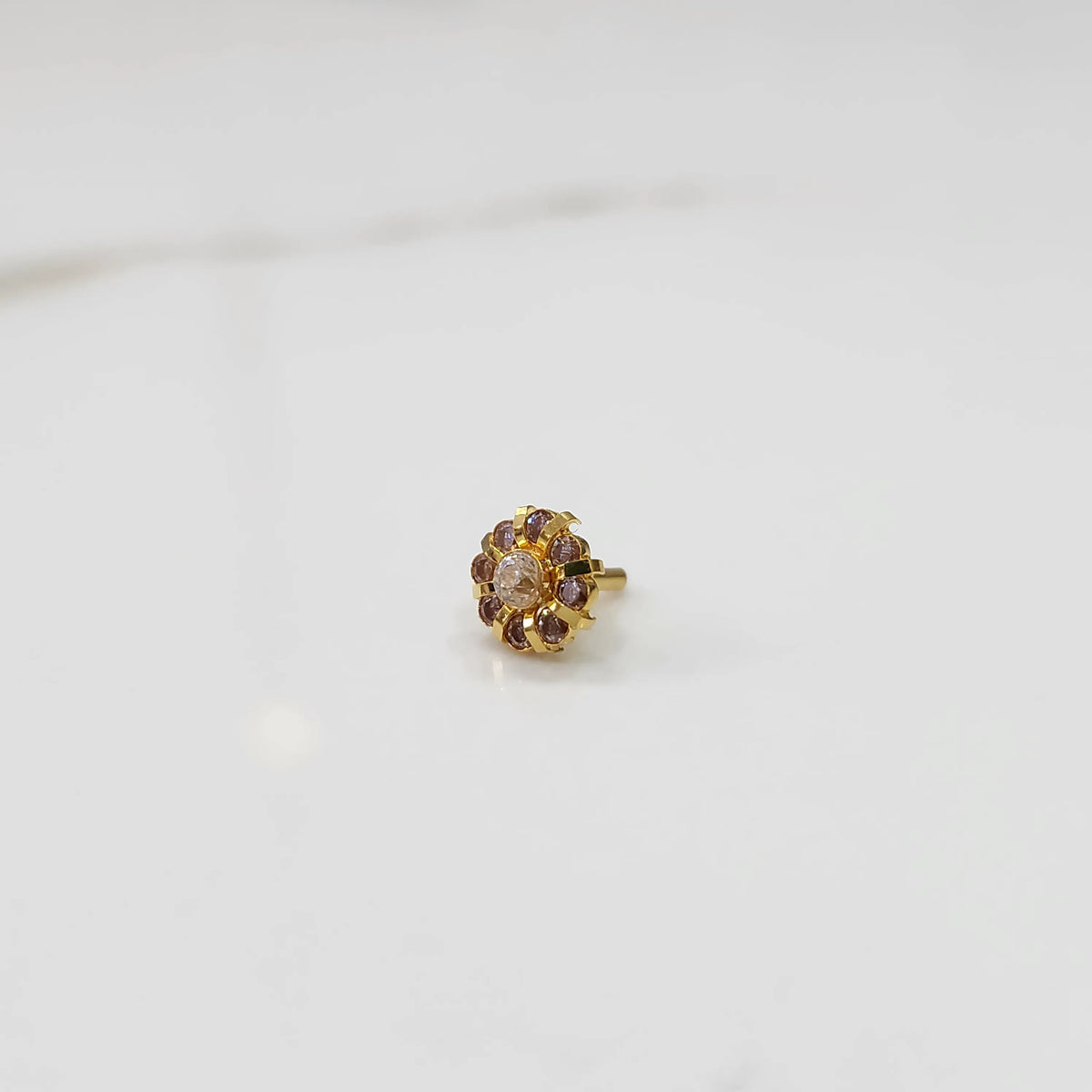 Gold ring with sculpted petal design and champagne center with purple stones