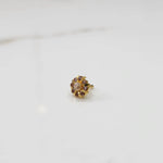 Gold ring with sculpted petal design and champagne center with purple stones