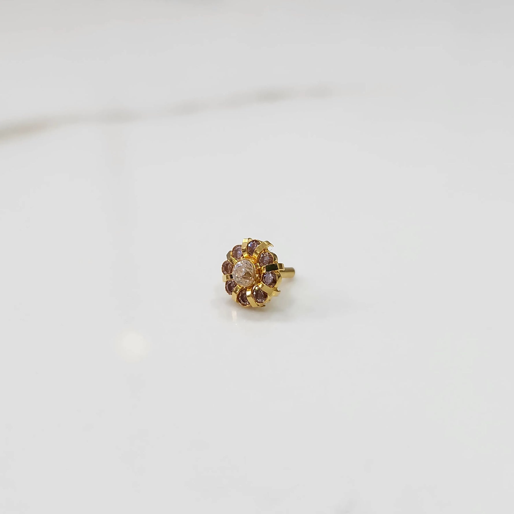 Gold ring with sculpted petal design and champagne center with purple stones