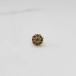 Traditional gold ring featuring rounded petals with white and champagne gemstones