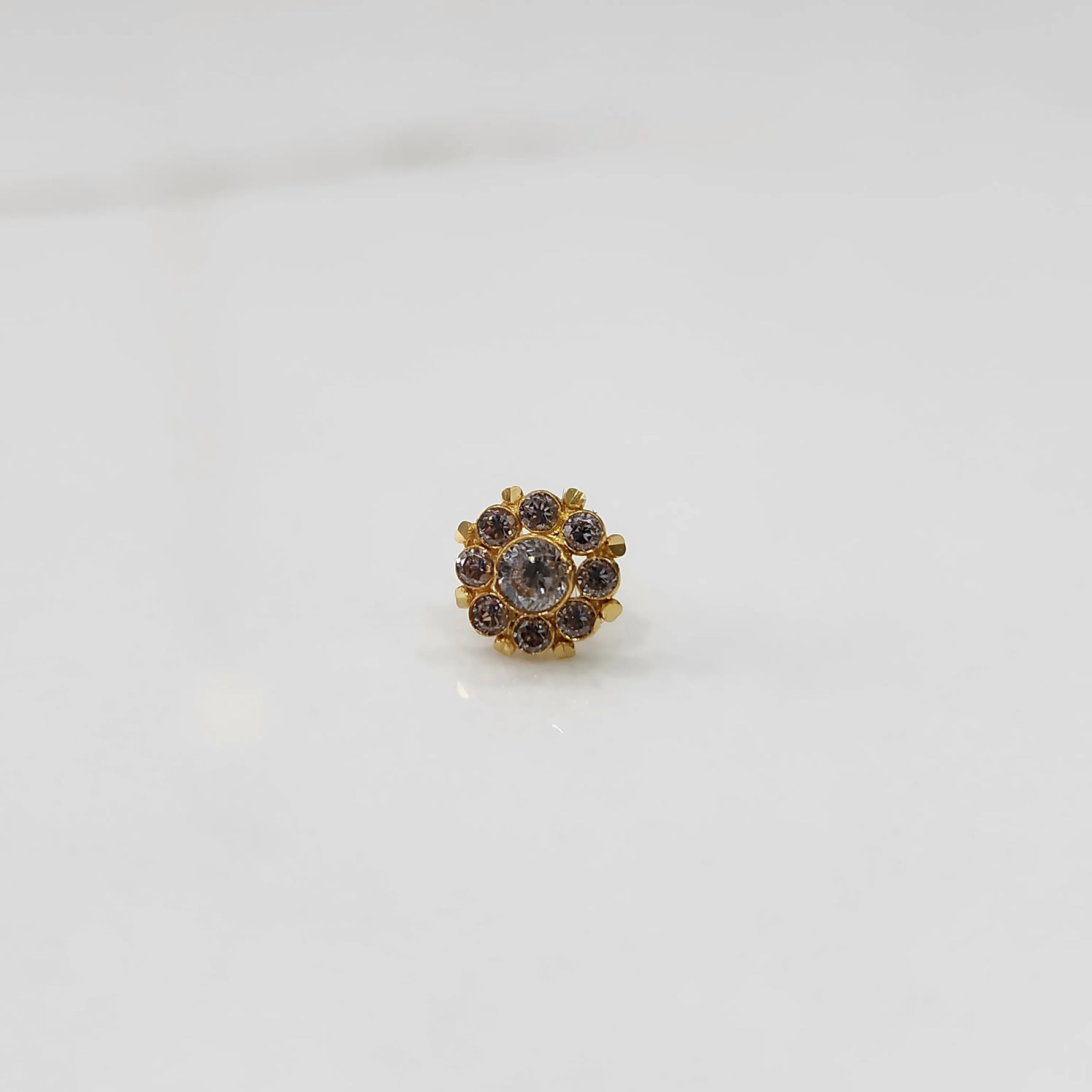 Traditional gold ring featuring rounded petals with white and champagne gemstones