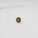 Top view of gold ring with clear center stone and purple petal stones