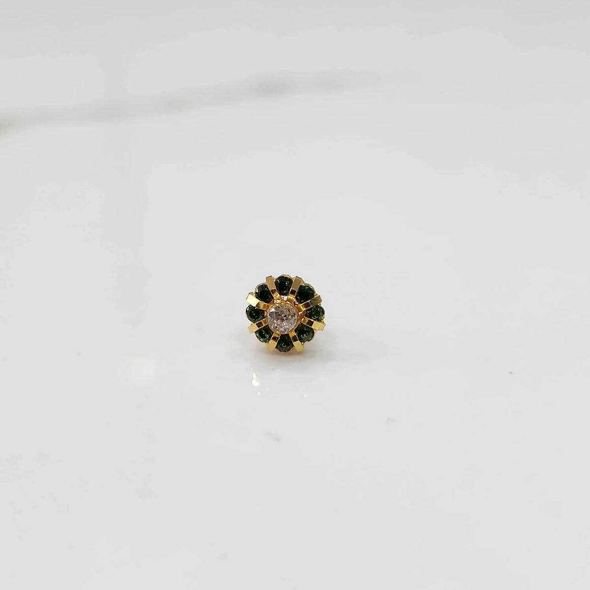 Close-up of gold ring featuring champagne and green gemstones