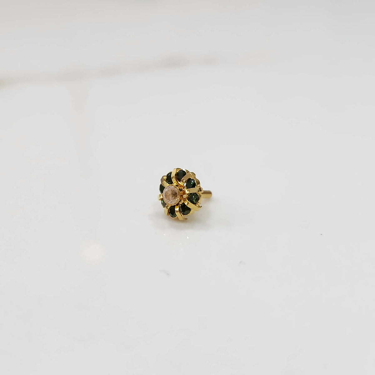 Gold ring with sculpted petal design and champagne center with green stones