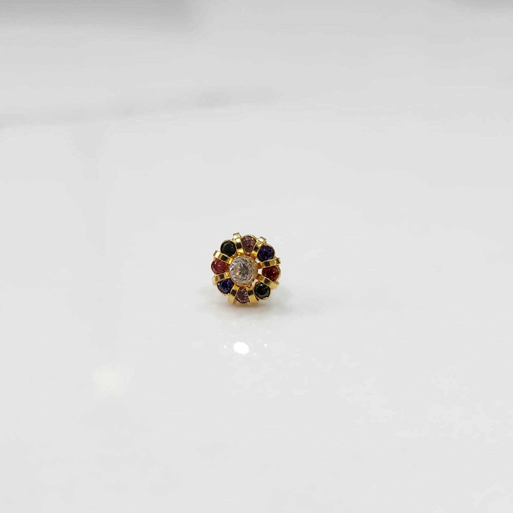 Top view of gold ring with clear center stone and navratna multicolor petals