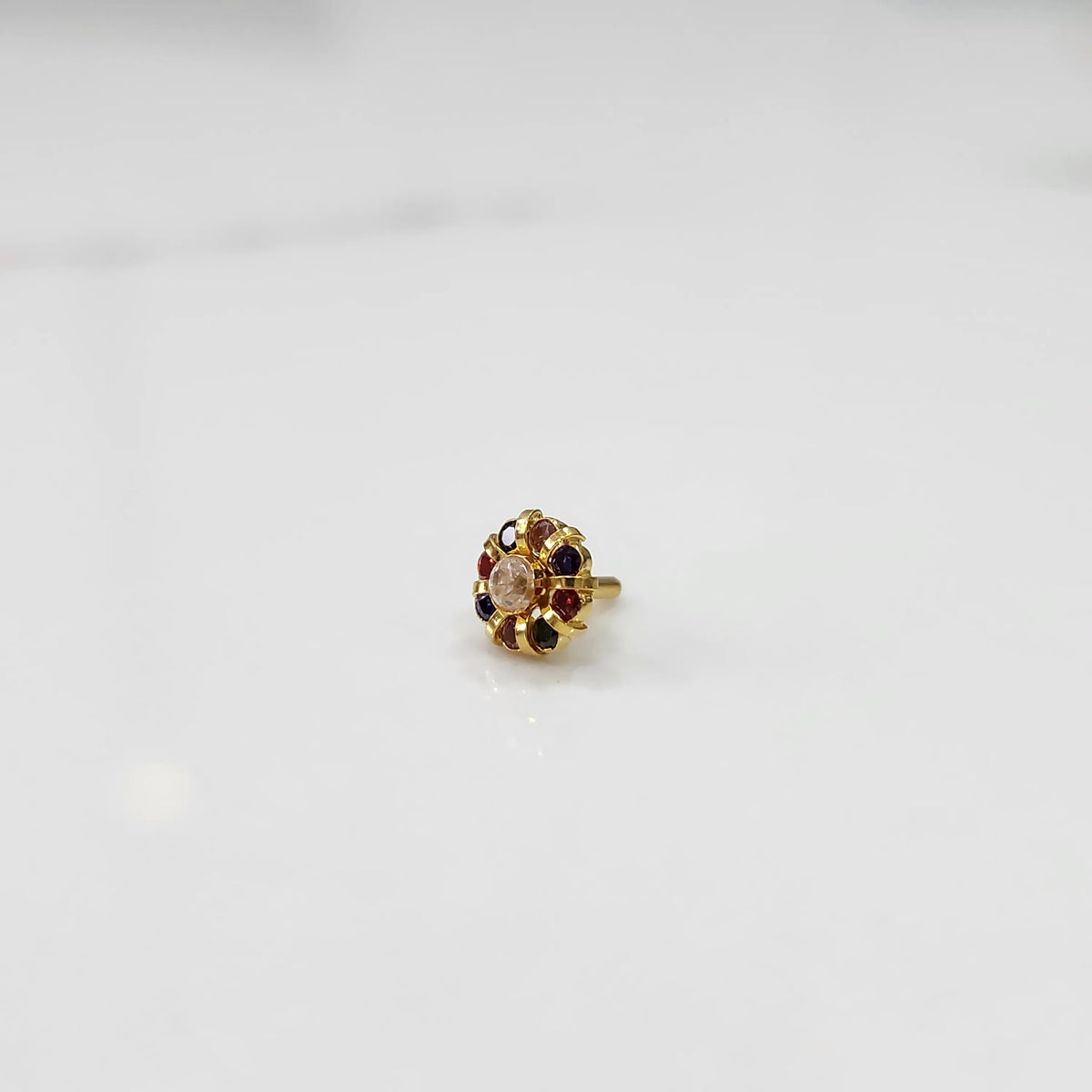 Gold ring with sculpted petal design and navratna multicolor stones