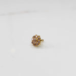 Traditional gold ring featuring rounded petals with peach and pink gemstones