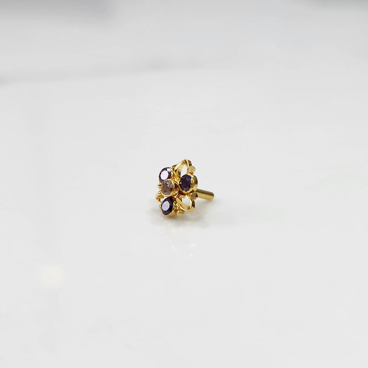 Gold ring with sculpted petal design and purple oval gemstones