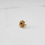 Traditional gold ring featuring rounded petals with red and champagne gemstones