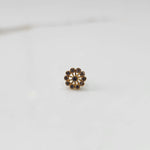 Front view of large gold nose pin with smoky-toned gemstone petals on white background