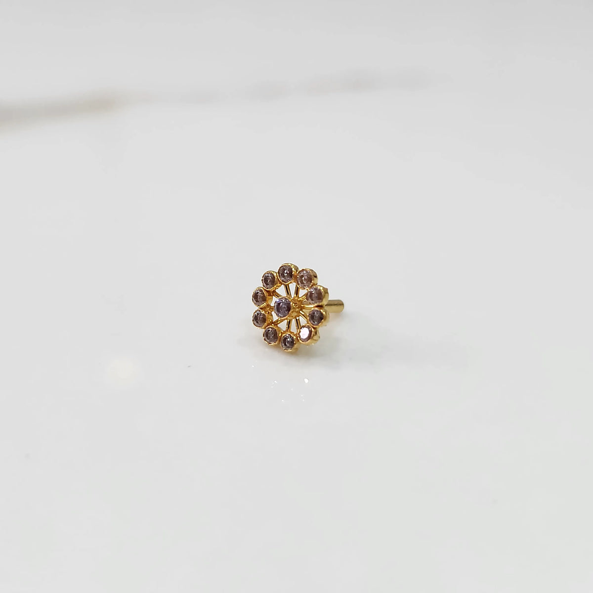 Large gold nose pin with smoky-toned gemstone petals and lilac center stone on white background