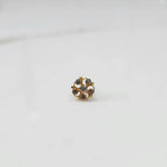 Gold nose pin with smoky-toned gemstone petals on white background