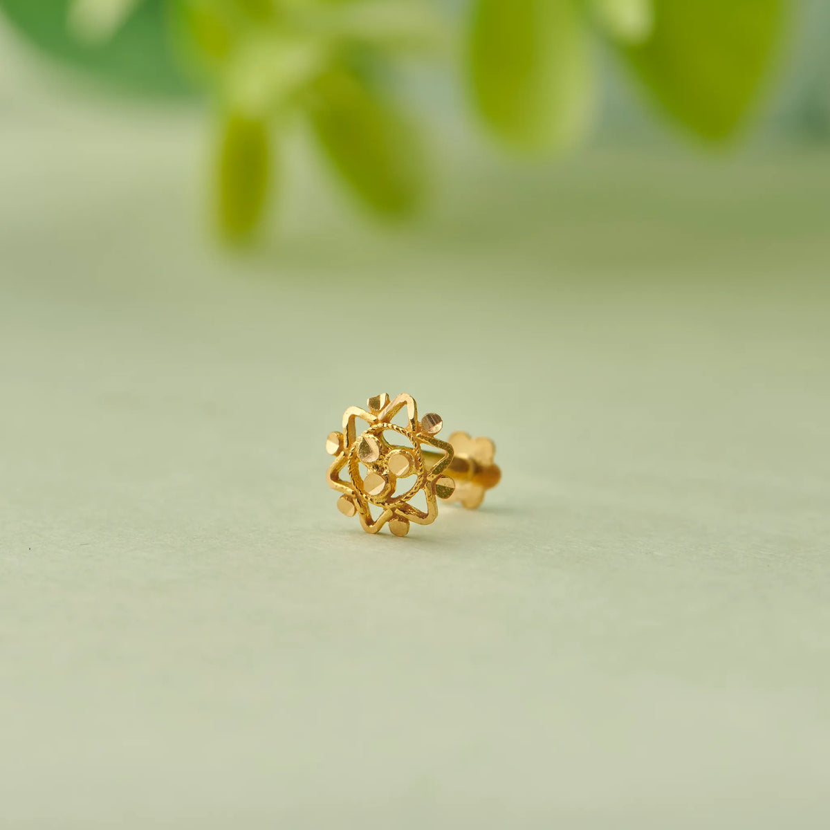 Gold stud earring with snowflake-style filigree design