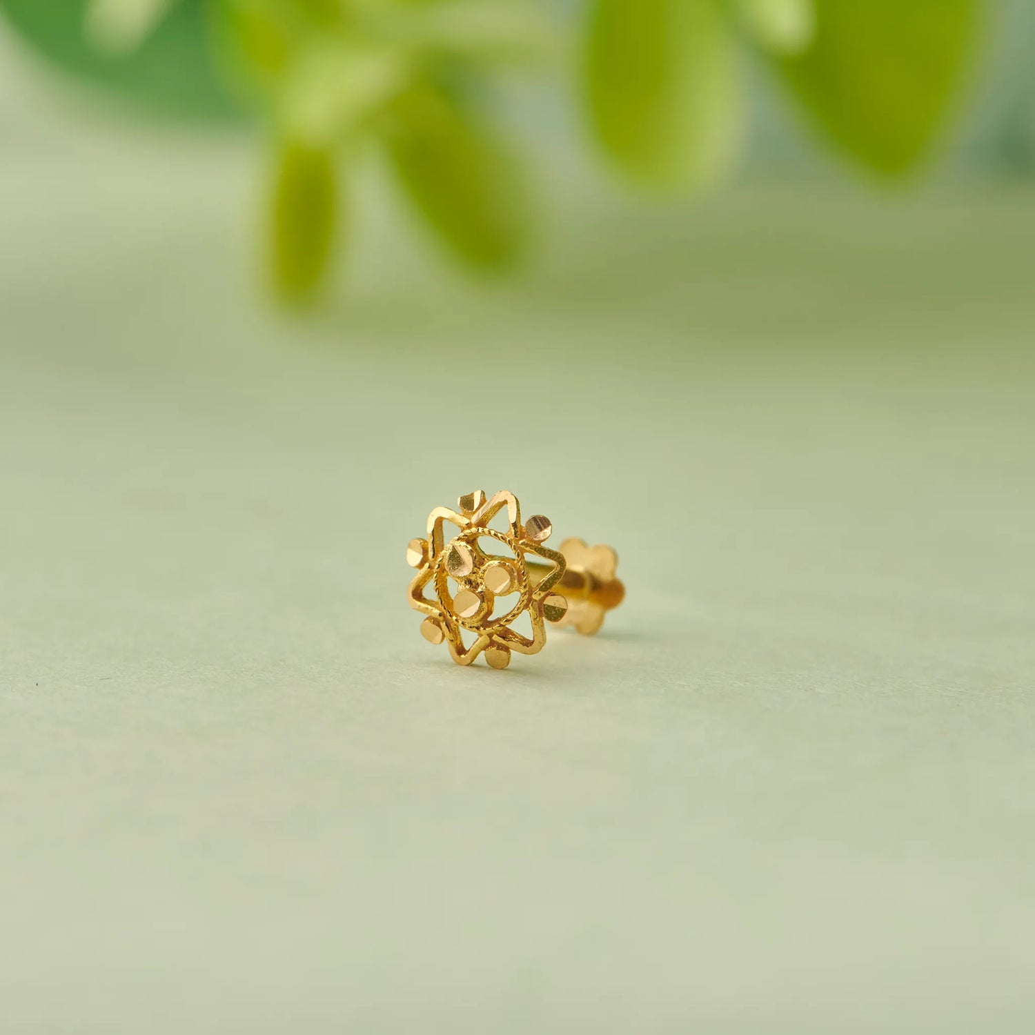 Gold stud earring with snowflake-style filigree design