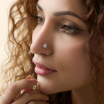 Woman wearing gold snowflake-shaped nose stud with white stones