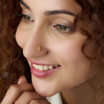 Woman wearing gold star flower nose pin with white stones