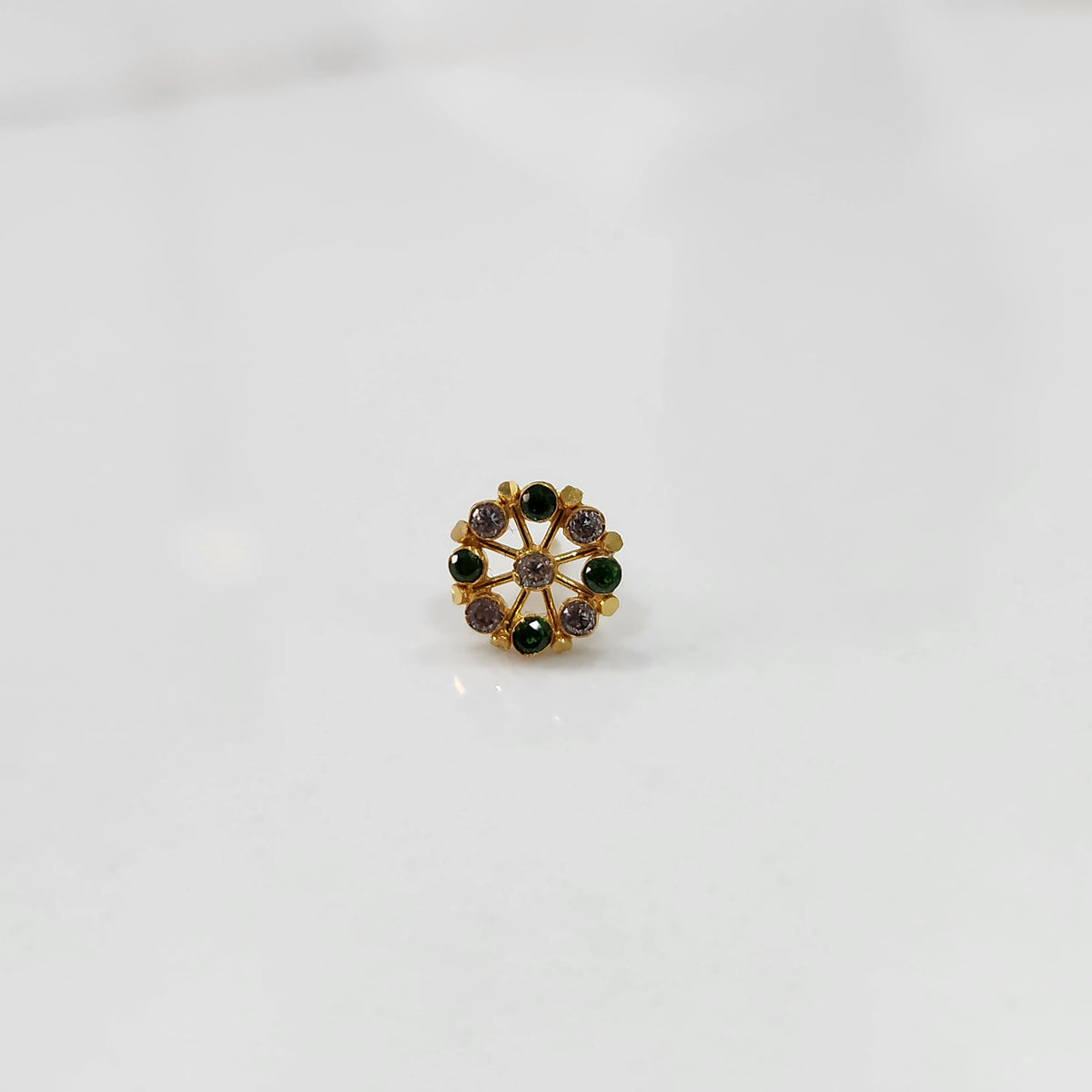 Gold pin nose with detailed floral gemstone pattern