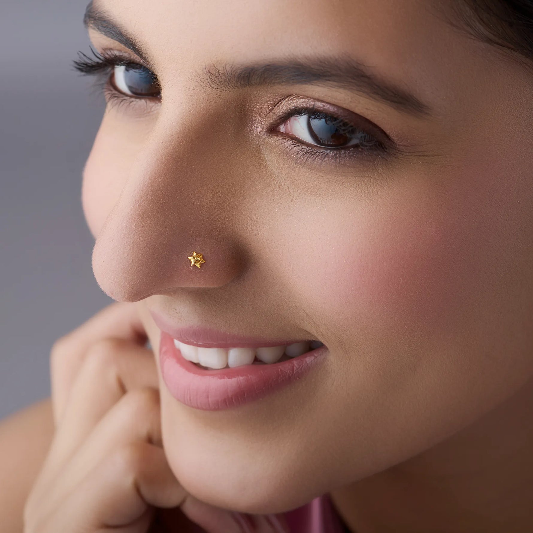 Woman wearing simple gold nose pin design star style