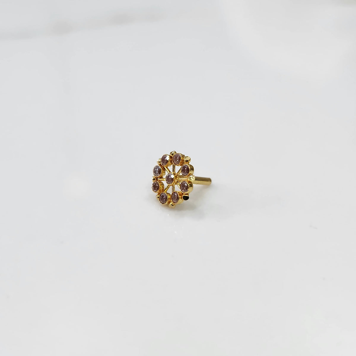 Gold star-frame nose pin with pink cabochon stones on white