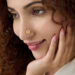 Woman wearing gold star-shaped nose pin with white stones