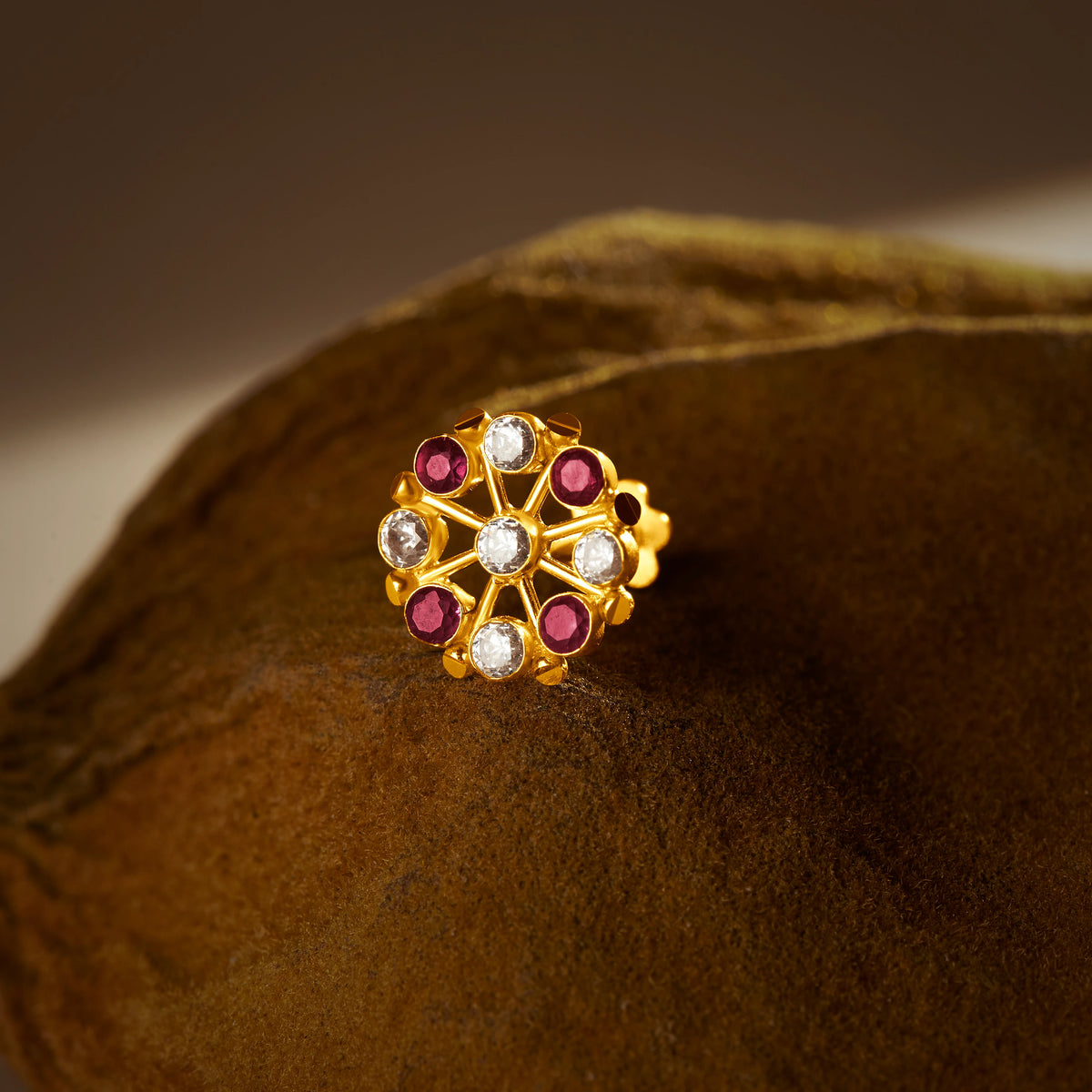 Gold pin nose with multi floral stone design on textured surface