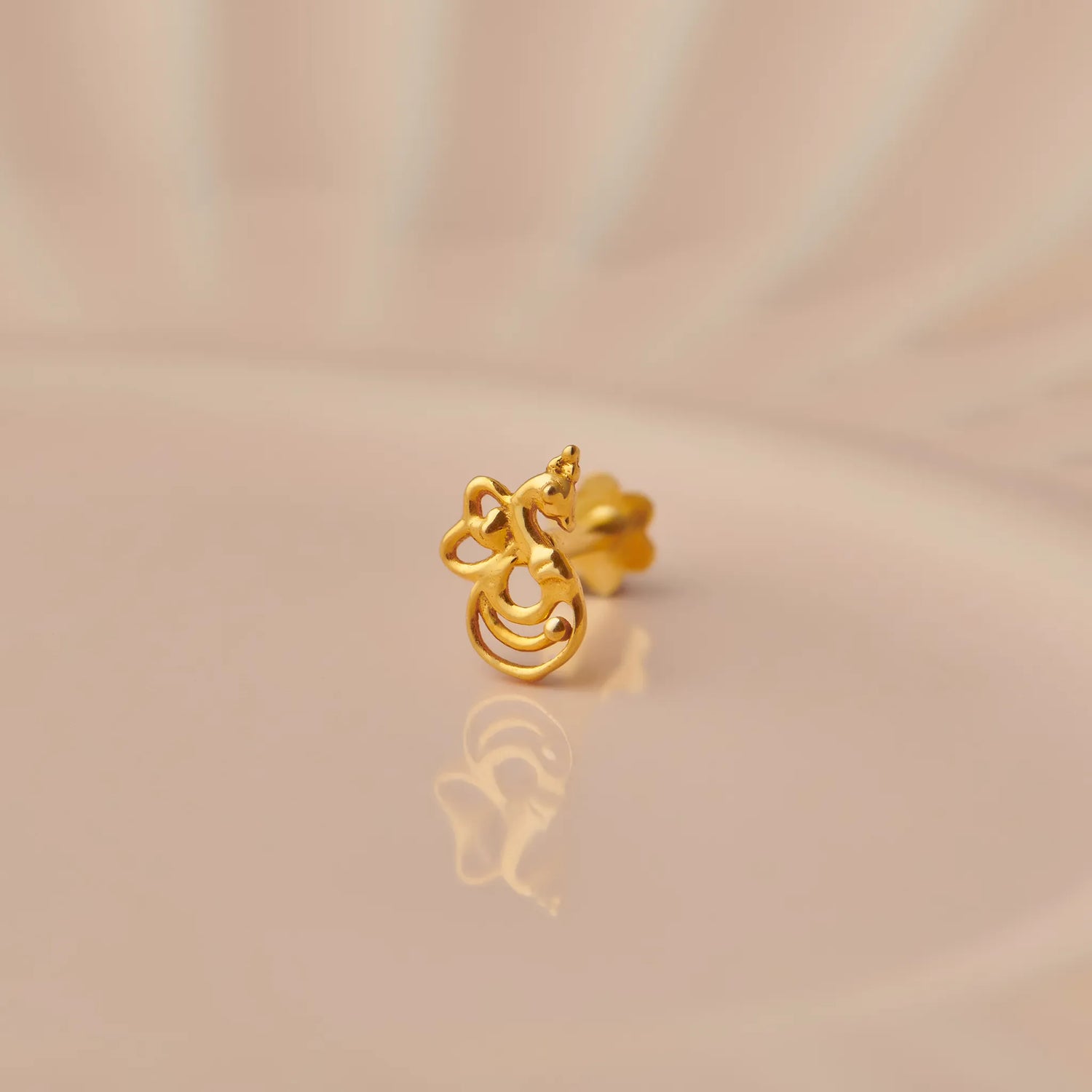 Gold stud earring with swirl and scroll cutout design