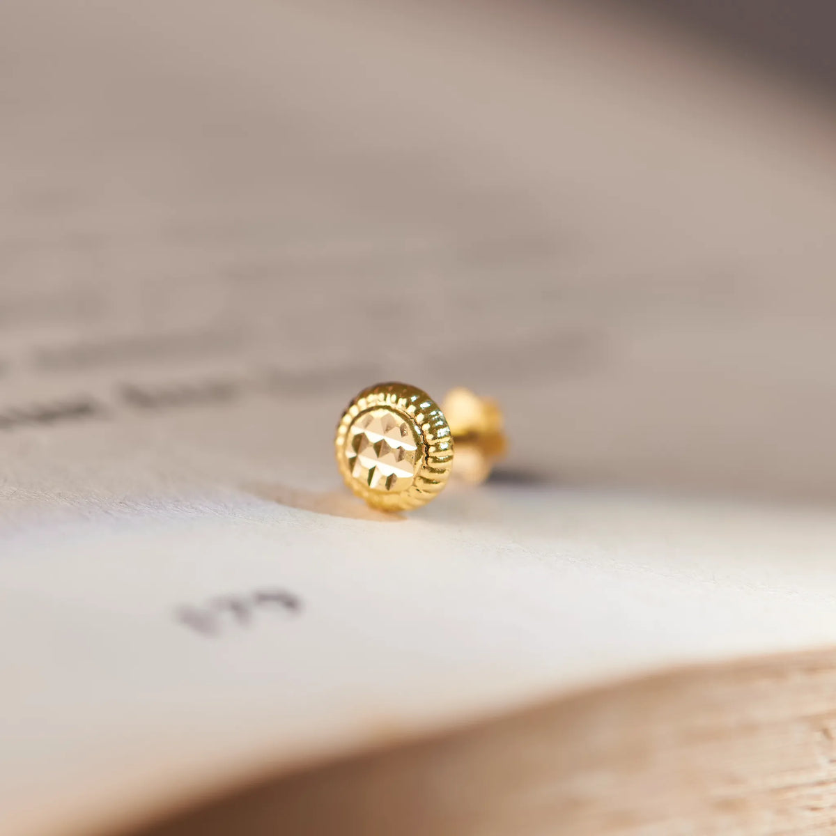 Gold round stud earring with ridged textured disc design