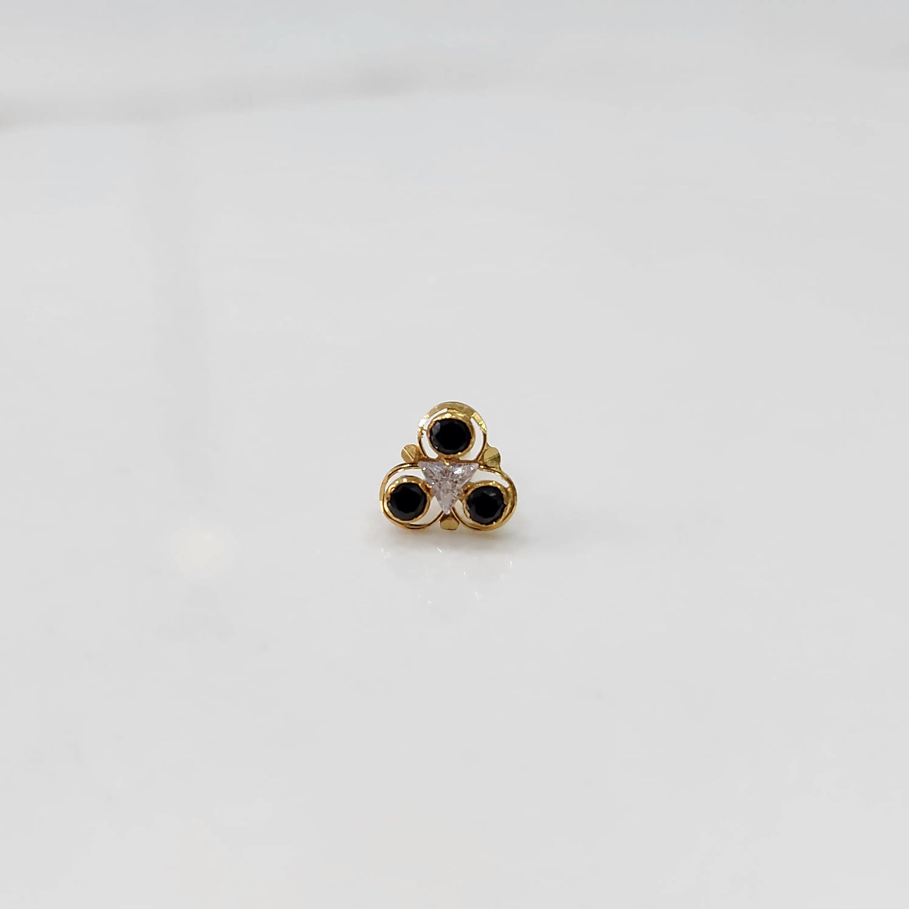 Top view of gold ring with black and clear stone cluster 