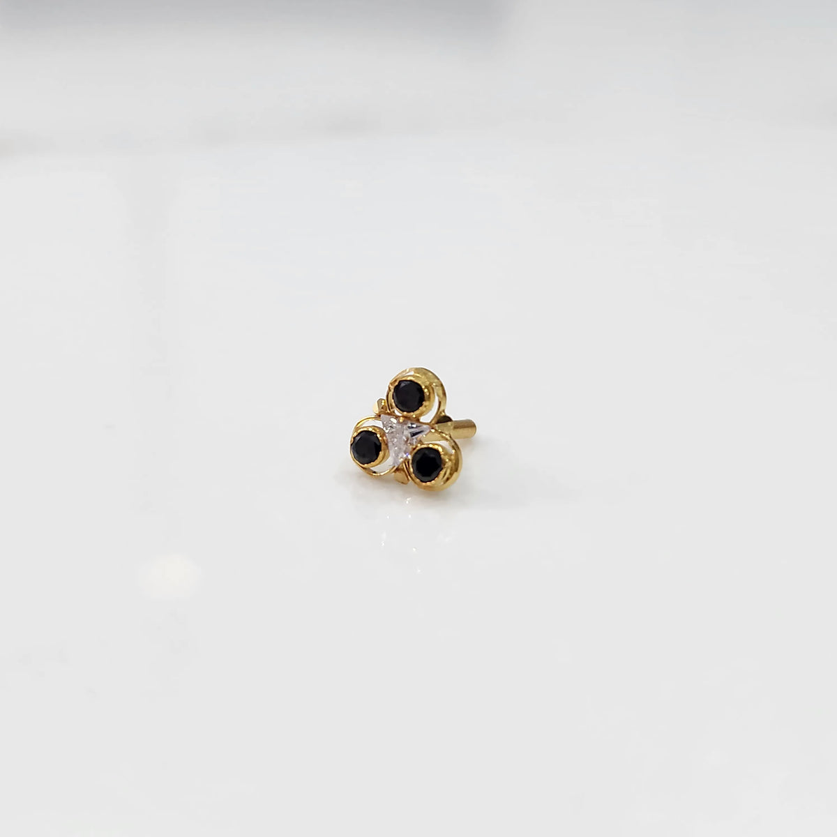 Gold ring with three-stone cluster in black and clear stones