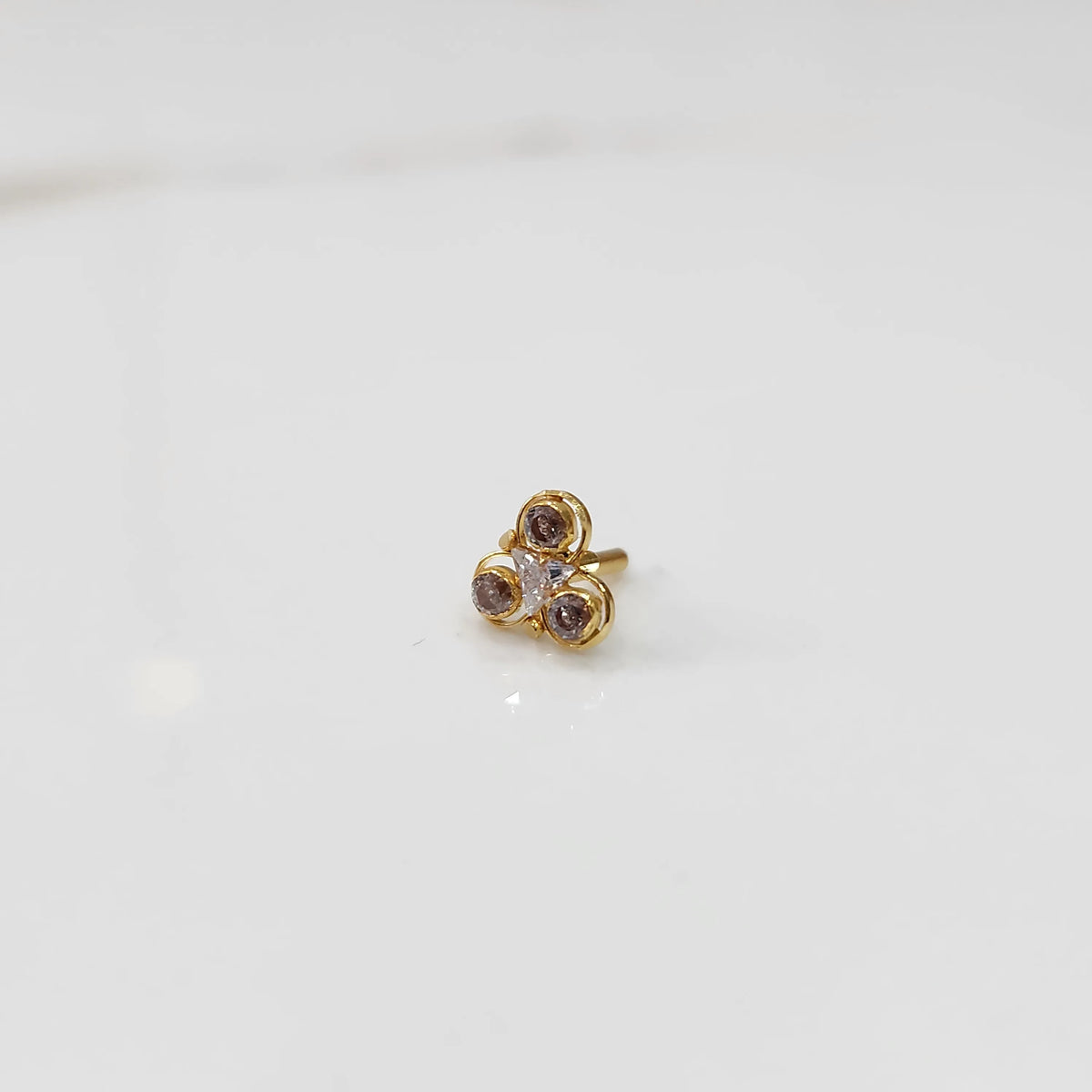 Gold ring with three-stone cluster in brown and clear stones