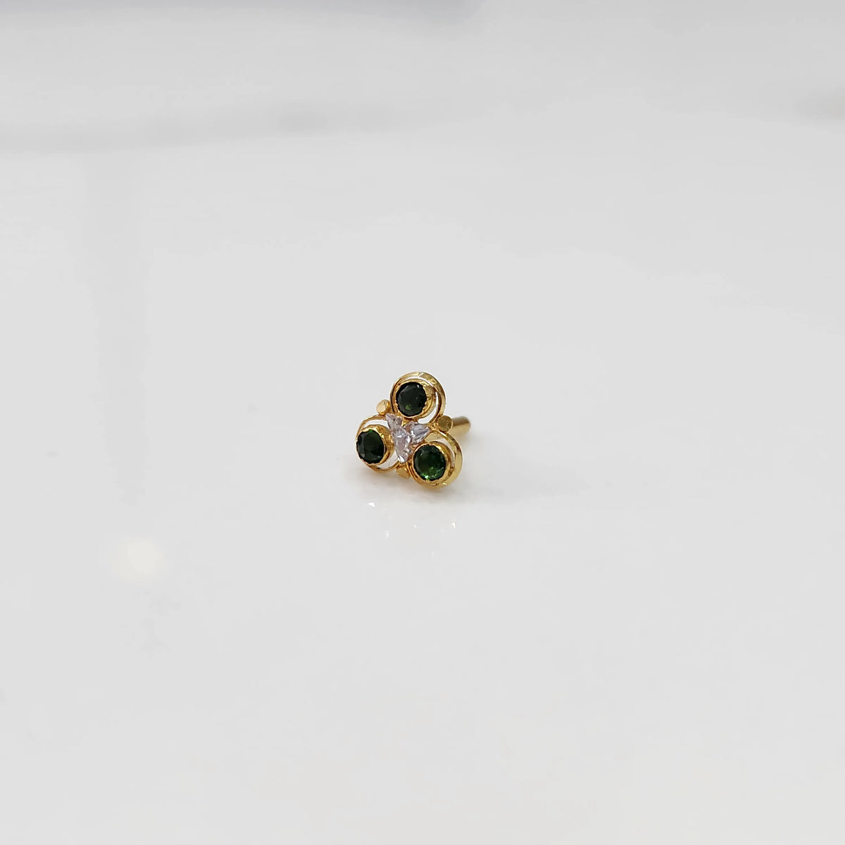 Gold ring with three-stone cluster in green and clear stones