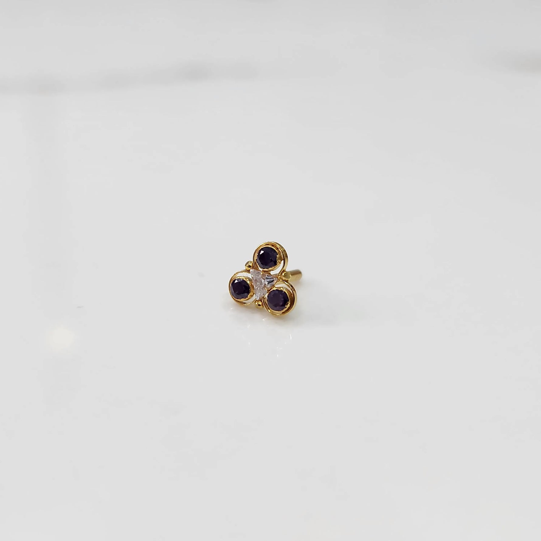 Gold ring with three-stone cluster in purple and clear stones