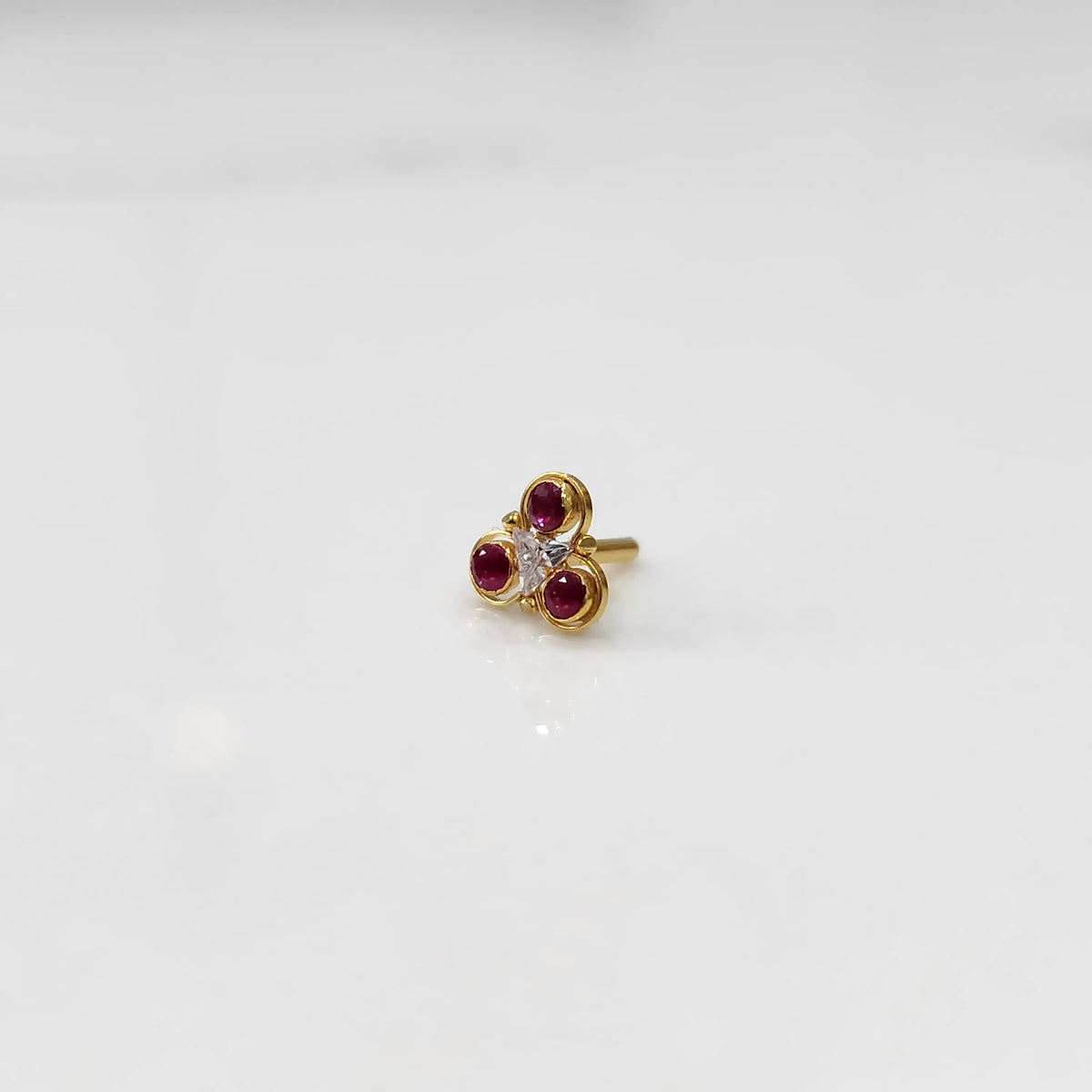 Gold ring with three-stone cluster in ruby-red and clear stones