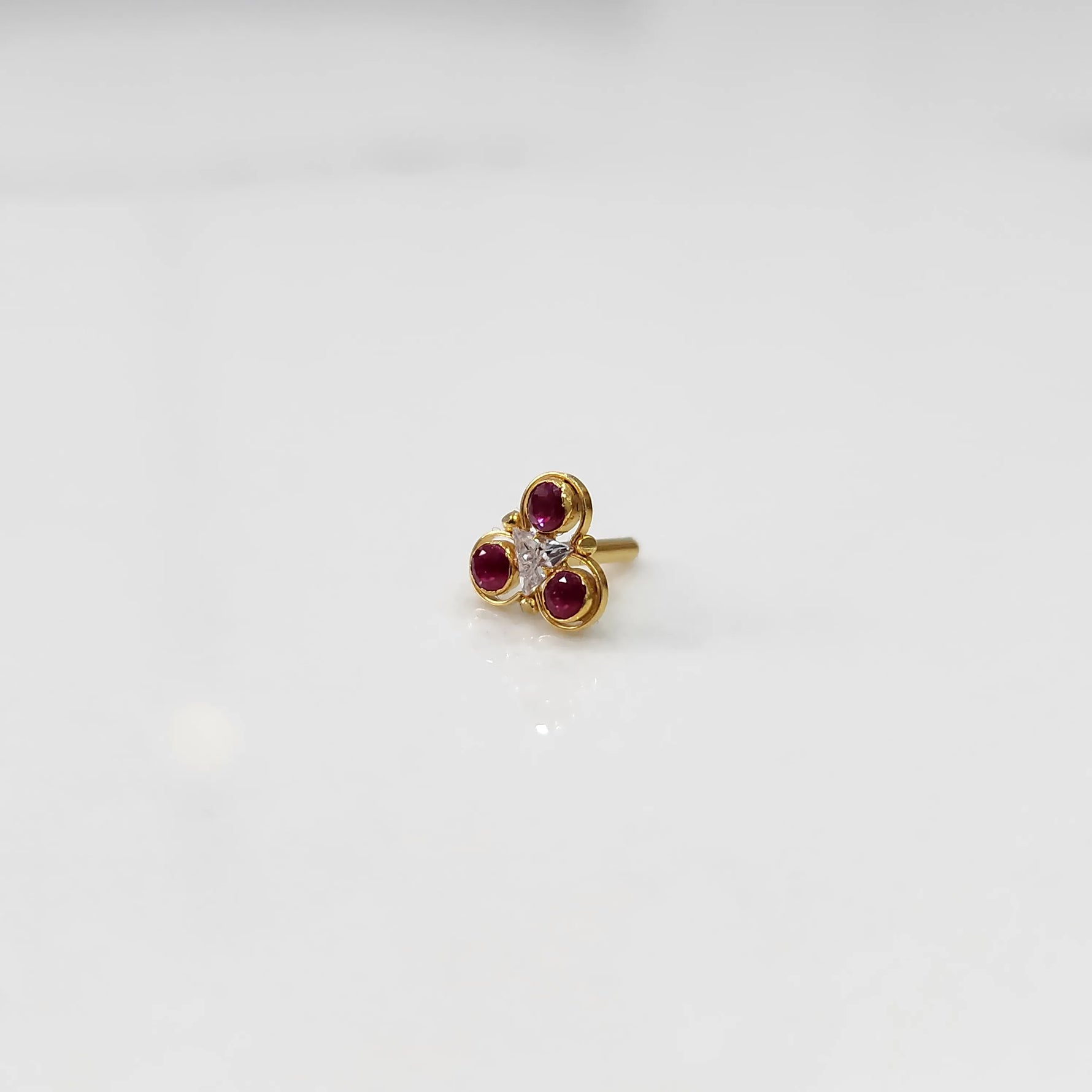 Gold ring with three-stone cluster in ruby-red and clear stones