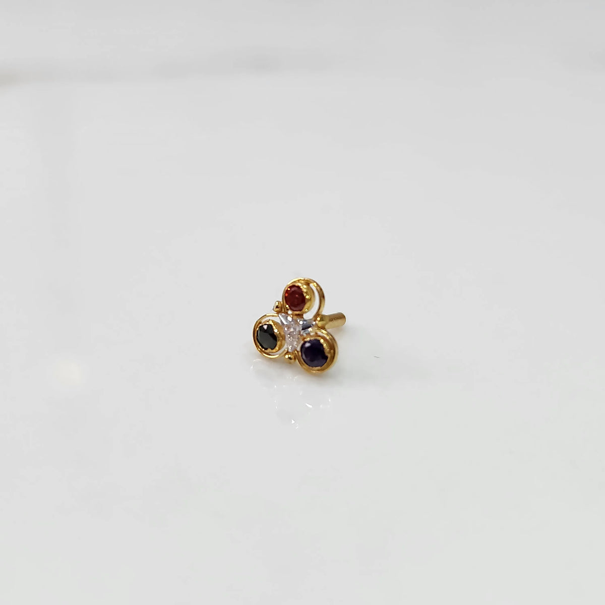 Gold ring with three-stone cluster in ruby-red, clear and blue