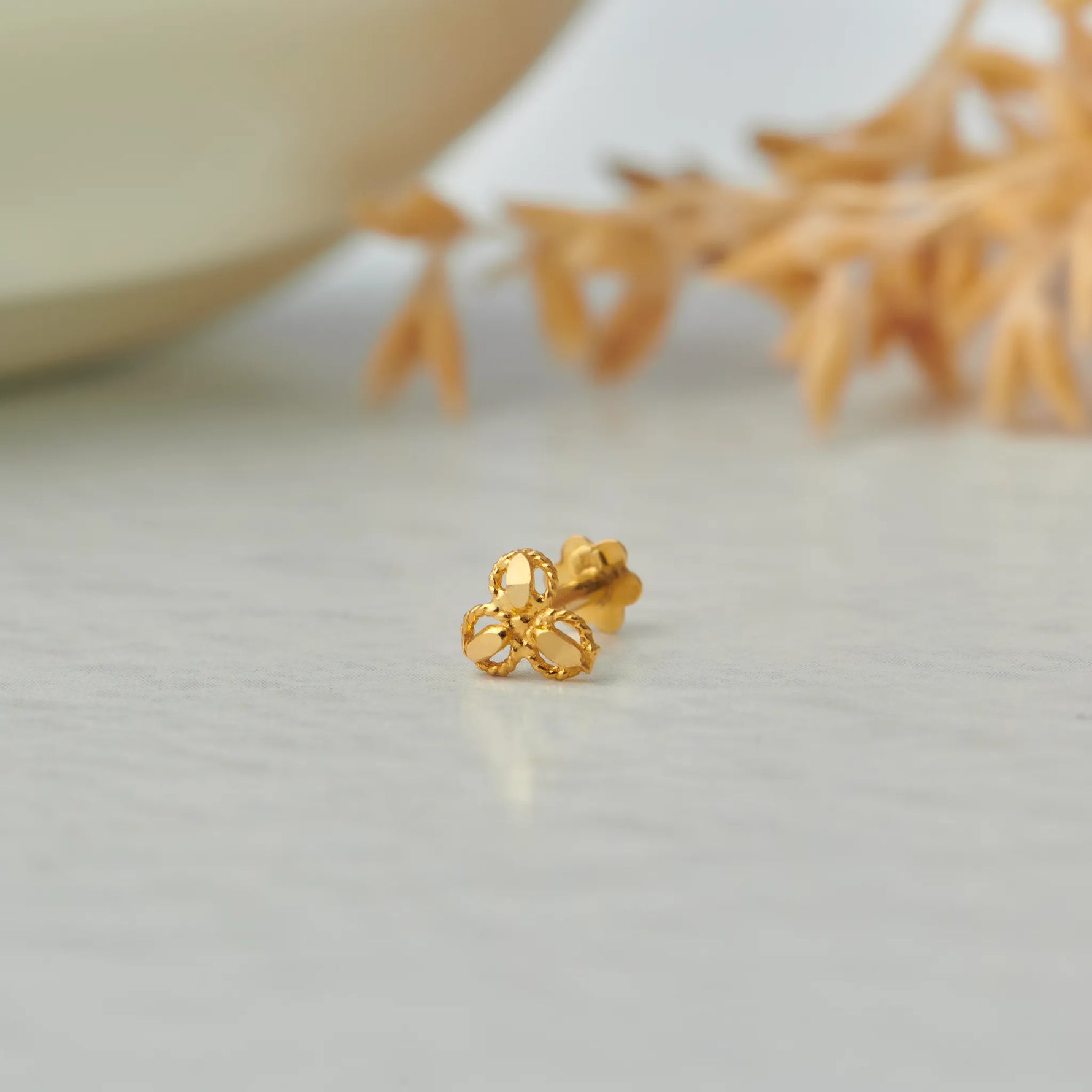 Gold trefoil-shaped stud earring with rope-edge loops
