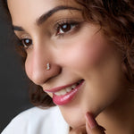 Woman wearing a vertical-set gold nose pin