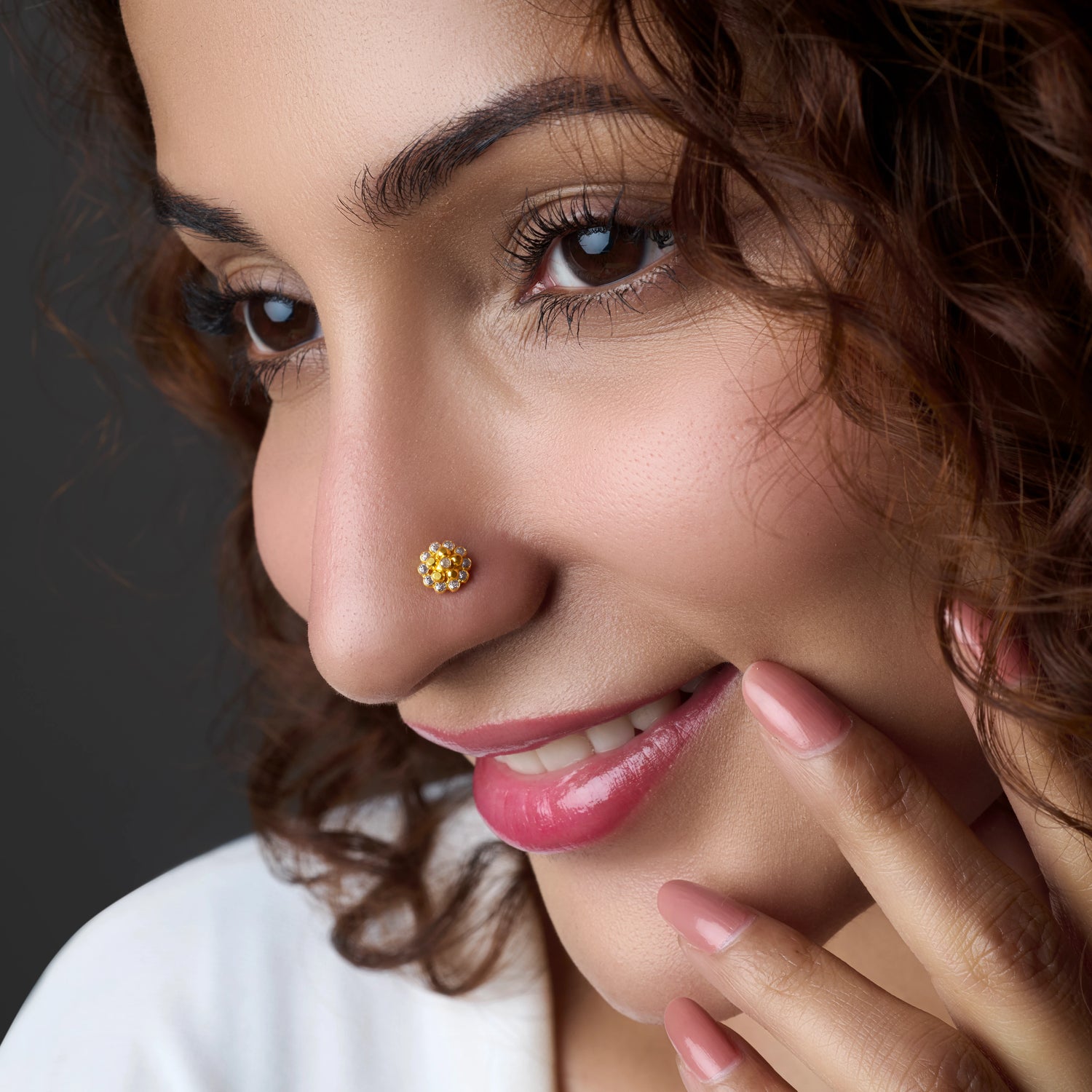Woman wearing a gold nose pin with yellow stones