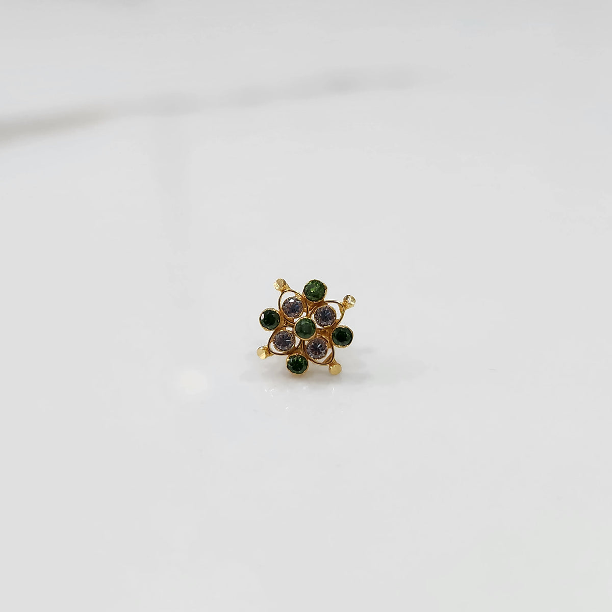 Stone gold nose pin angled view with soft lighting
