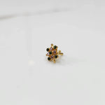 Mini stone gold nose pin floral design top view on white surface