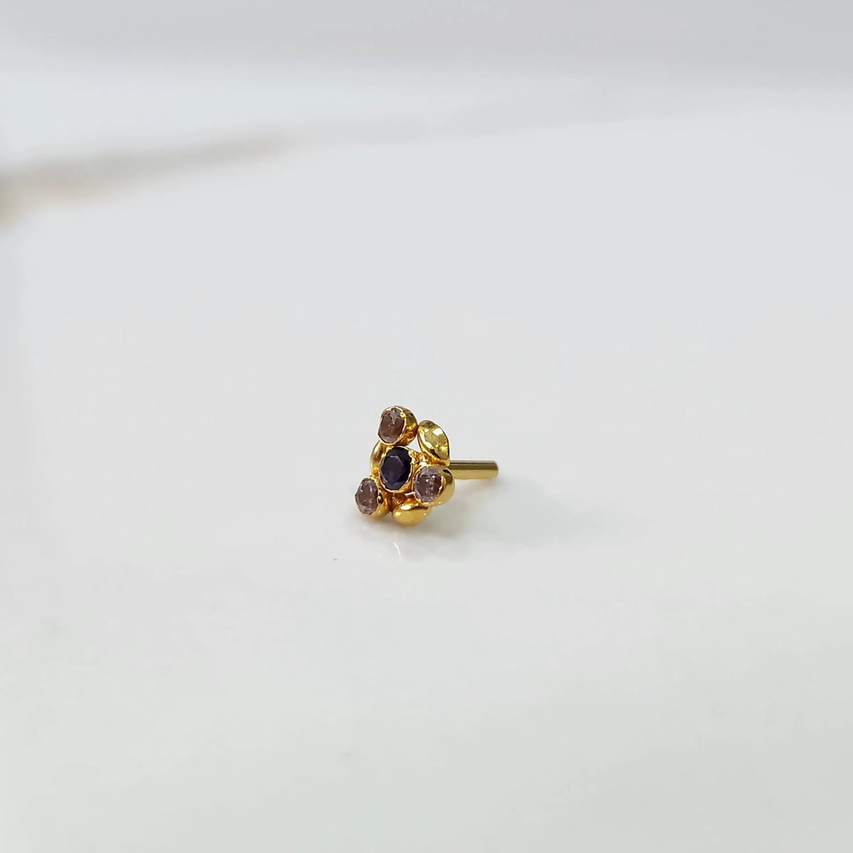 Front view of gold ring featuring black gemstone cluster with leaf accents