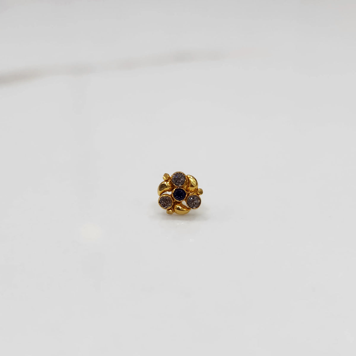 Gold ring with blue and purple gemstone round floral design, front view