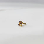 Side angle of gold ring featuring blue gemstone flower design