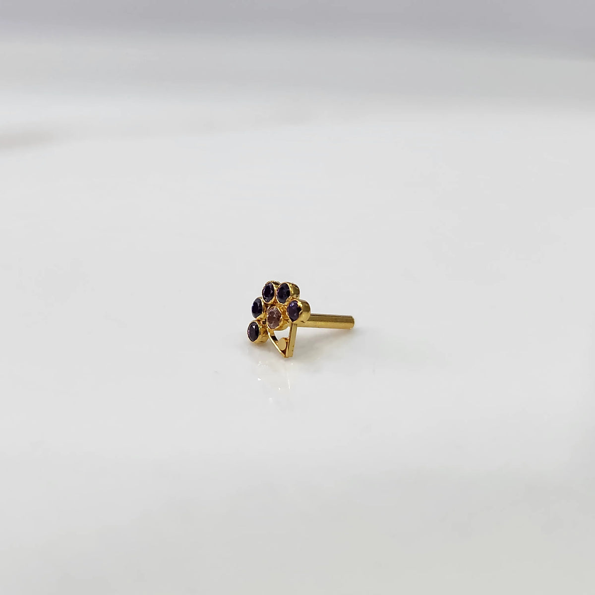 Side angle of gold ring featuring blue gemstone flower design