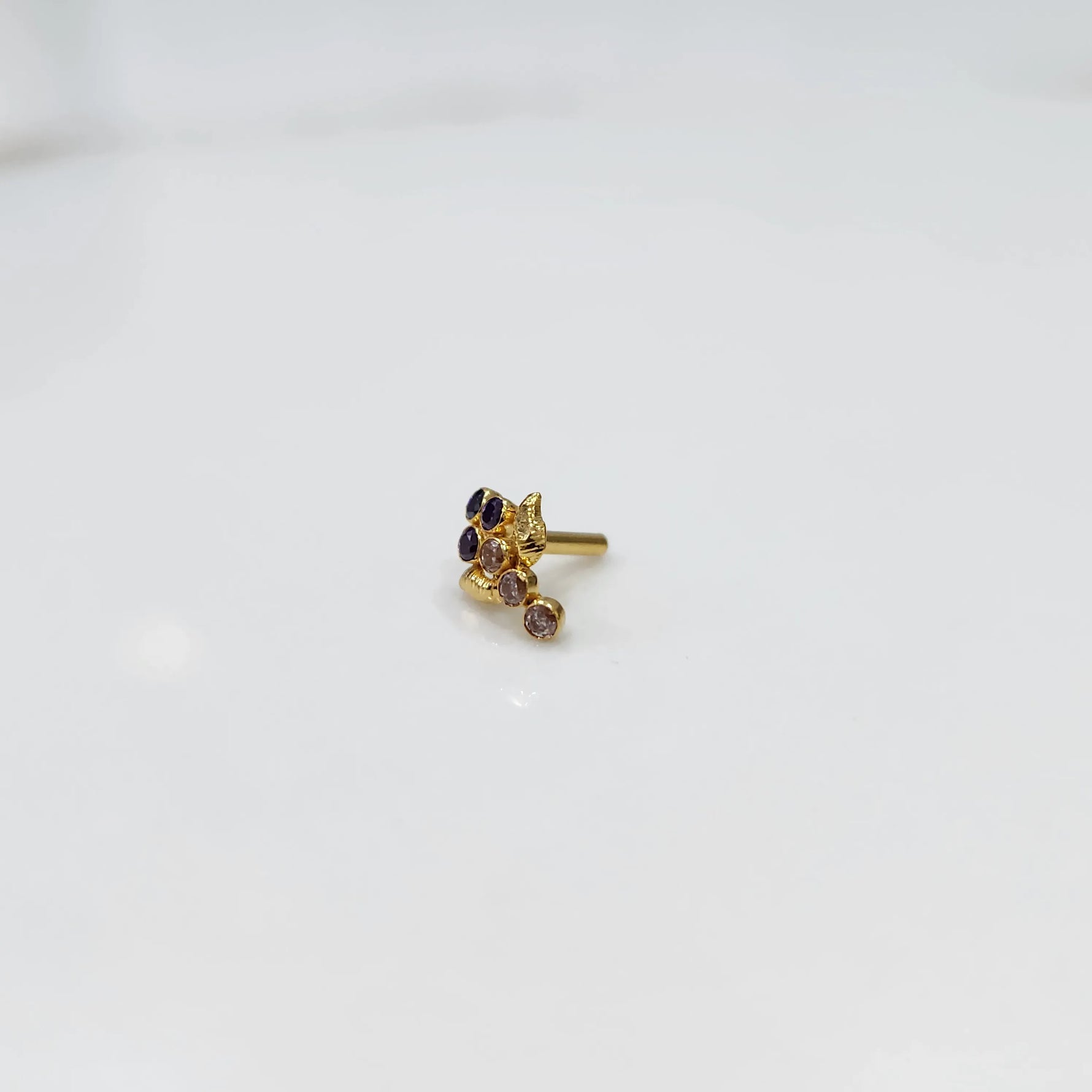 Side view of gold ring featuring blue gemstone cluster with leaf and drop accent