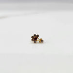 Antique-style gold ring with clear-toned stones, ruby center, plus hanging accent
