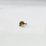 Antique-style gold ring with emerald-toned stones, clear center, plus hanging accent