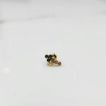 Antique-style gold ring with green and purple-toned stones in leaf-charm pattern