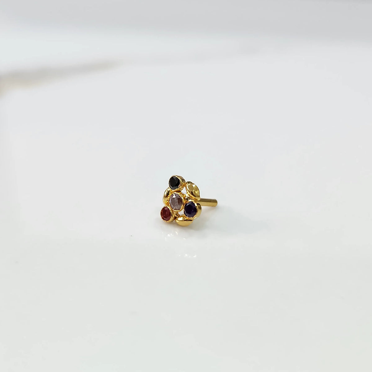Antique-style gold ring with multicolor stones in leaf-petal pattern, angled view