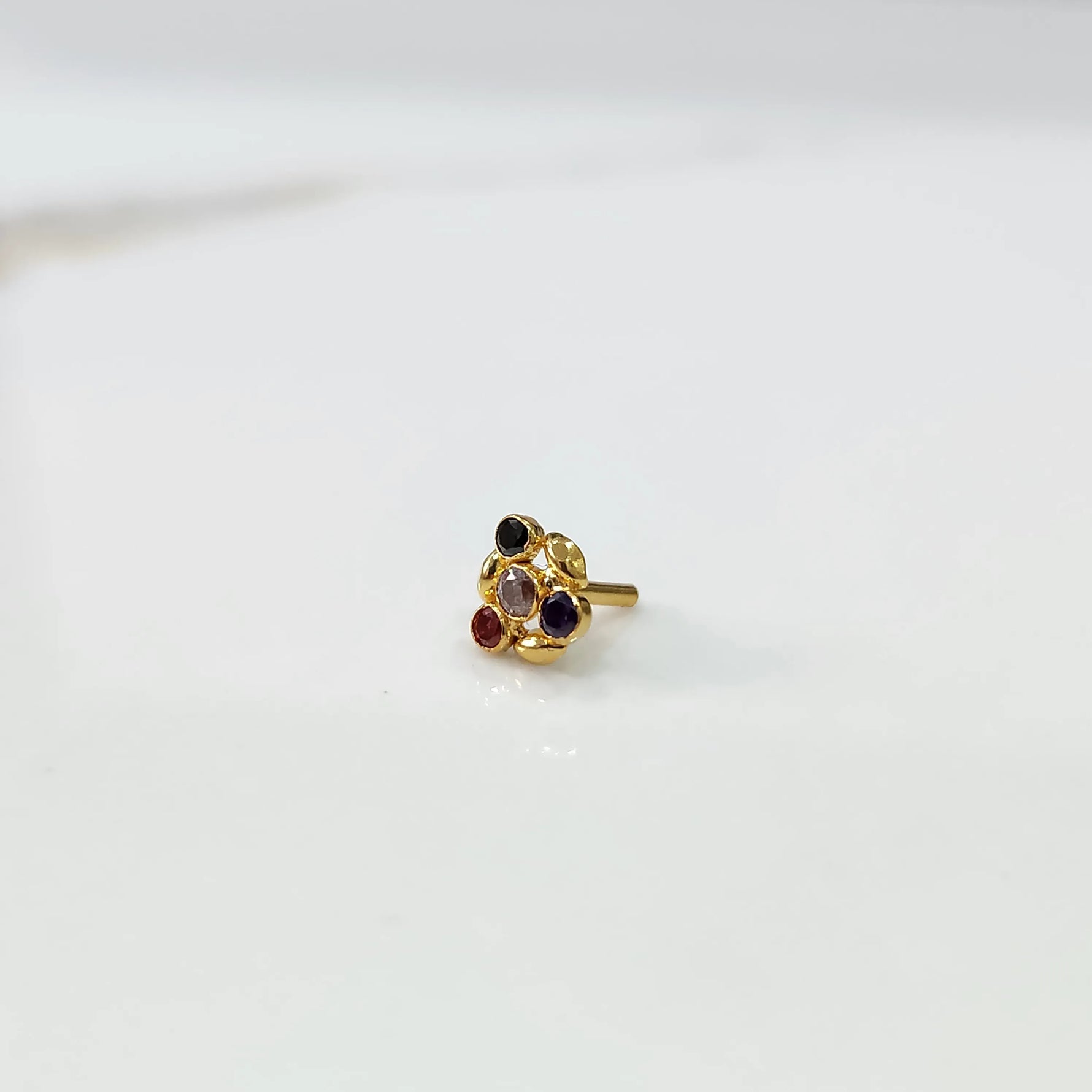 Antique-style gold ring with multicolor stones in leaf-petal pattern, angled view